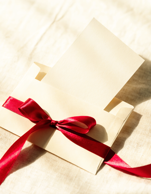 Buono regalo XO Boutique con busta in carta crema e nastro fucsia