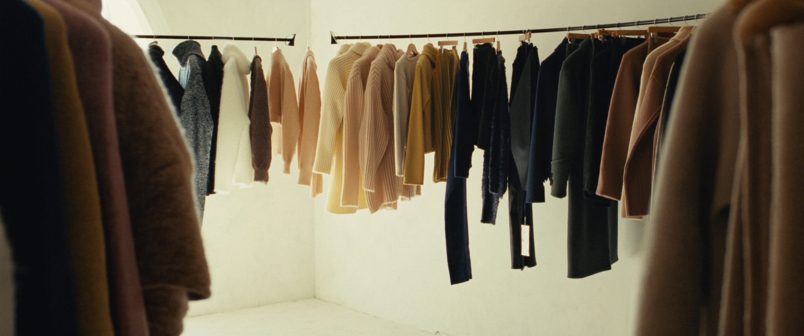 Stand di abbigliamento nella boutique XO, toni crema e cammello