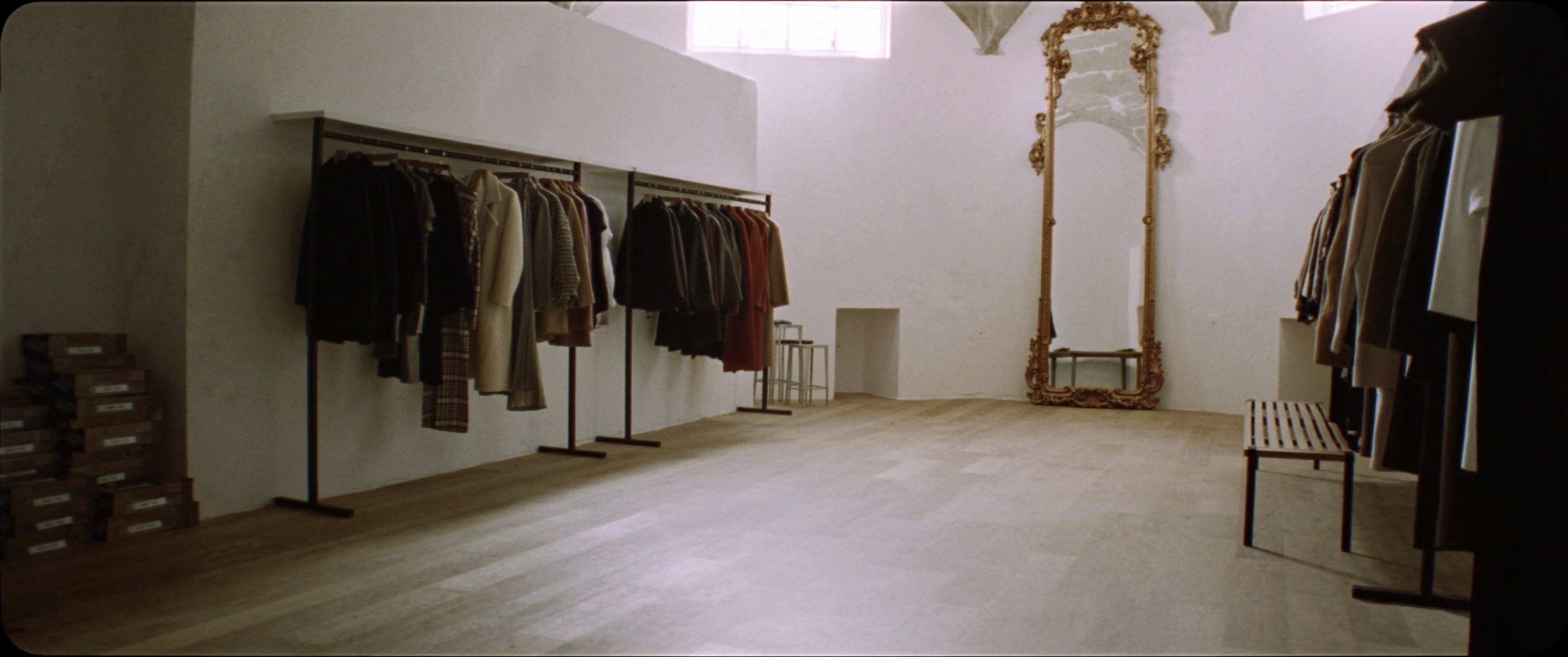 Interno della boutique XO: pareti chiare, parquet e specchio antico
